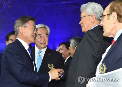 South Korean President Moon Jae-in (L) shakes hands with Chang Ung, a North Korean member of the International Olympic Committee, during the opening ceremony of the World Taekwondo Federation (WTF) World Taekwondo Championships at T1 Arena in Taekwondowon in Muju, North Jeolla Province, on June 24, 2017. (Yonhap)