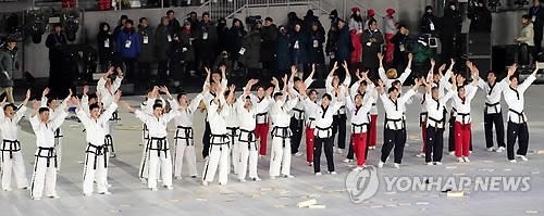 In this file photo taken on Feb. 9, 2018, taekwondo practitioners from South and North Korea respond to spectators at the Olympic Stadium in PyeongChang, Gangwon Province, after they finished a joint taekwondo demonstration performance before the opening ceremony of the PyeongChang Winter Olympic Games. (Yonhap) 