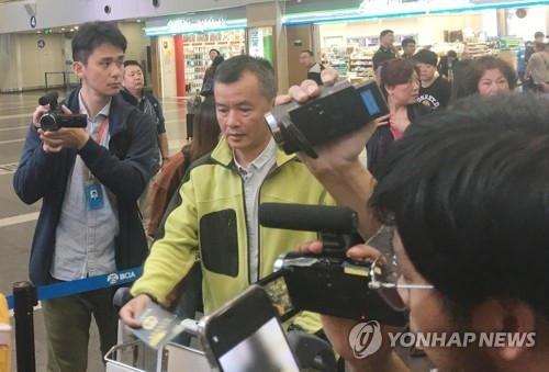 International journalists invited by Pyongyang to cover the dismantlement of its key nuclear test site head toward a chartered plane bound for North Korea at Beijing Capital International Airport on May 22, 2018. (Yonhap)