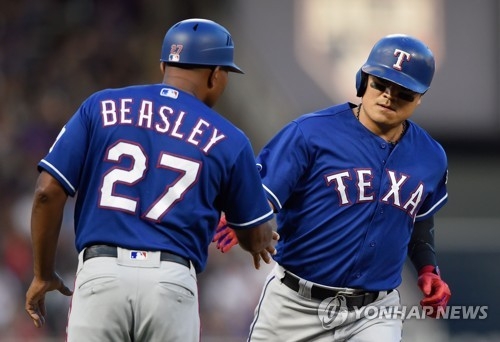 In this Getty Images photo, Choo Shin-soo of the Texas Rangers (R) is congratulated by his third base coach Tony Beasley after hitting a two-run homer against the Minnesota Twins in the top of the fifth inning of a major league regular season game at Target Field in Minneapolis, Minnesota, on June 22, 2018. (Yonhap)