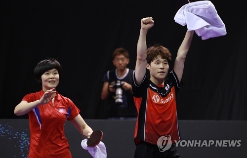 Cha Hyo-sim of North Korea (L) and Jang Woo-jin of South Korea celebrate their victory over Chen Chien-An and Cheng I-Ching of Taiwan in the mixed doubles semifinals at the International Table Tennis Federation World Tour Platinum Korea Open at Chungmu Sports Arena in Daejeon, 160 kilometers south of Seoul, on July 20, 2018. (Yonhap)