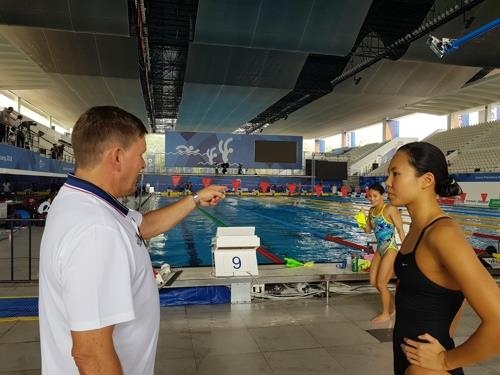 South Korean swimmer An Se-hyeon (R) listens to her coach Michael Bohl during practice at GBK Aquatic Center in Jakarta on Aug. 16, 2018, ahead of the 18th Asian Games. (Yonhap)