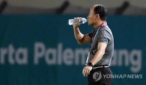 South Korea's U-23 football head coach Kim Hak-bum drinks water during a men's football match against Malaysia at the 18th Asian Games at Si Jalak Harupat Stadium in Bandung, Indonesia, on Aug. 17, 2018