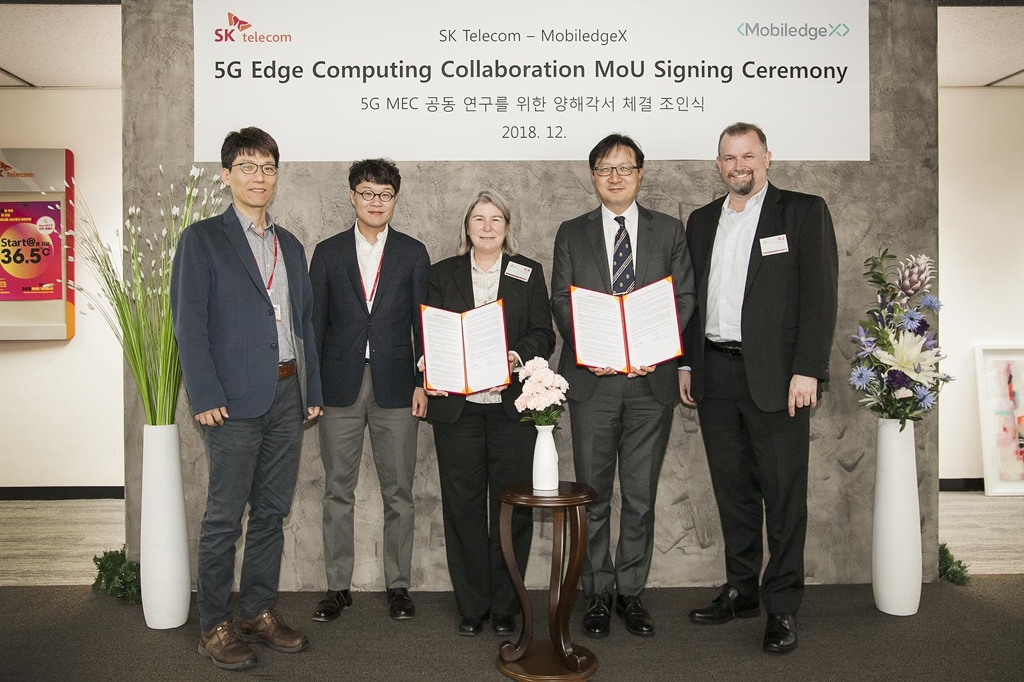 Officials from SK Telecom Co. and MobiledgeX, an affiliate of Deutsche Telekom, pose for a photo after signing an agreement in this photo released by SK Telecom on Dec. 13, 2018. (Yonhap)