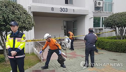 Police and firefighters inspect the scene of a fire and murders at an apartment building in Jinju, southeastern South Korea, on April 17, 2019. (Yonhap)