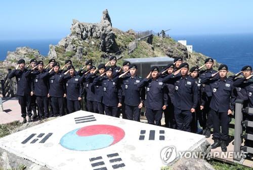 Coast guard members stationed on South Korea's easternmost Dokdo Islets salute the national flag while resolving to uphold the islets' defense one day ahead of Liberation Day on Aug. 14, 2019. (Yonhap)