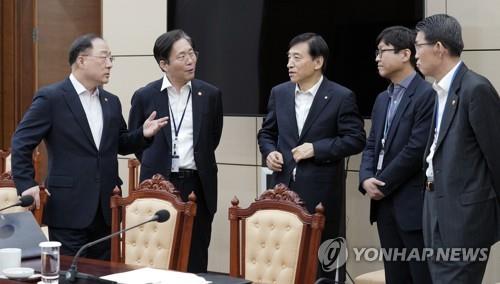 This photo taken on March 13, 2020 shows Finance Minister Hong Nam-ki (L) and Bank of Korea Governor Lee Ju-yeol (C) and other economy-related ministers in talks after an emergency meeting at the presidential office of Cheng Wa Dae in Seoul. (Yonhap)