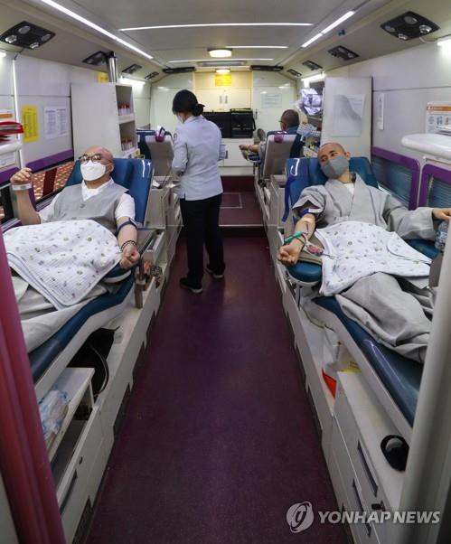 Buddhist monks donate blood inside a bus of the Korea Red Cross at Jogye Temple in Seoul on March 24, 2020, amid a shortage of blood due to the spread of the new coronavirus. (Yonhap) 