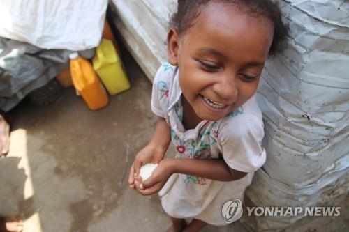 This undated photo, provided by the World Food Program (WFP), shows a Yemeni child holding rice sent from South Korea. (PHOTO NOT FOR SALE) (Yonhap)