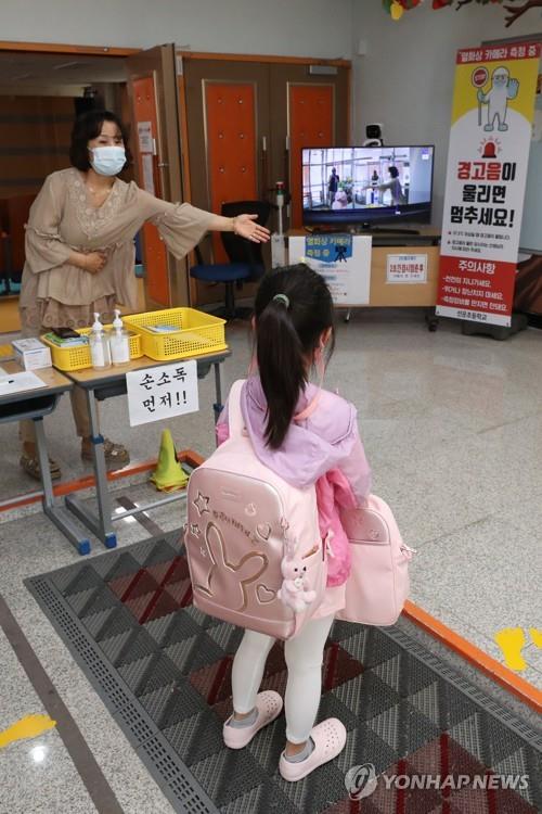 A teacher conducts mandatory temperature testing for students through a thermal imaging camera at an elementary school in the southwestern city of Gwangju on Sept. 14, 2020, as the school reopens following its implementation of online classes amid fears over the spread of the new coronavirus. (Yonhap)