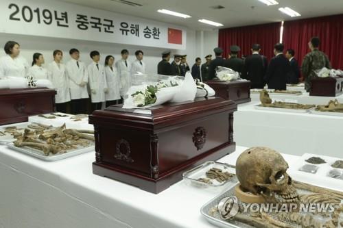 The file photo taken April 1, 2019, shows South Korean and Chinese officials holding a ceremony in Incheon, west of Seoul, to put the remains of Chinese soldiers killed in the 1950-53 Korean War into coffins for their repatriation. (Yonhap)