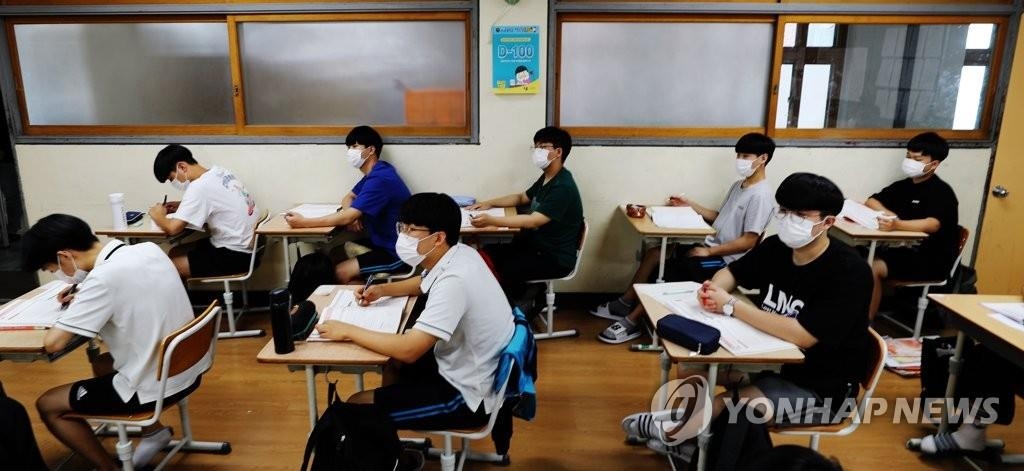 High school seniors wearing masks attend class in this undated file photo. (Yonhap)