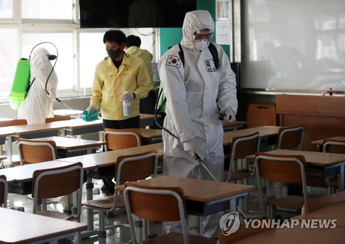 Officials spray disinfectants at a school in Daegu, 302 km southeast of Seoul, on Feb. 23, 2021. (Yonhap)