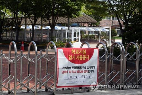 A notice of temporary closure is posted on the gate of a high school in the southwestern city of Gwangju on May 6, 2021, after 13 of the school's students tested positive for the new coronavirus. (Yonhap)