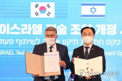 Industry Minister Moon Sung-wook (R) and his Israeli counterpart Amir Peretz pose for a photo at a hotel in central Seoul on May 12, 2021, after signing a bilateral agreement to expand ties in research and development projects and prepare for the post-pandemic era. (Yonhap)