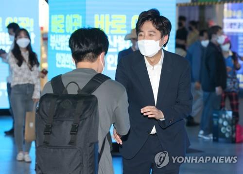 Lee Jun-seok (R), a 36-year-old candidate for the main opposition People Power Party's leadership race, shakes hands with a voter at an underground mall in Busan, about 450 kilometers southeast of Seoul, on June 2, 2021. (Yonhap)