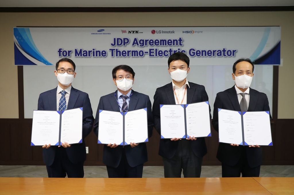 Officials from Samsung Heavy Industries Co., LG Innotek Co., HSD Engine Co. and Japan's NYK Line pose for a picture, holding business agreements, in this photo provided by the shipbuilder on Oct. 13, 2021. (PHOTO NOT FOR SALE) (Yonhap) 
