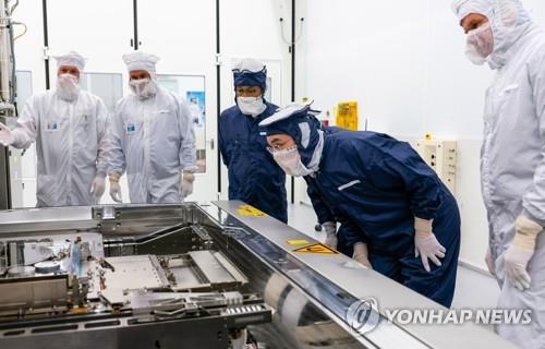 This file photo, provided by Samsung Electronics on Oct. 13, 2020, shows Vice Chairman Lee Jae-yong (2nd from R) looking at extreme ultraviolet (EUV) equipment essential for producing chips during his visit to the headquarters of ASML Holding N.V., the world's leading photolithography equipment maker, in Eindhoven, the Netherlands. (PHOTO NOT FOR SALE) (Yonhap)