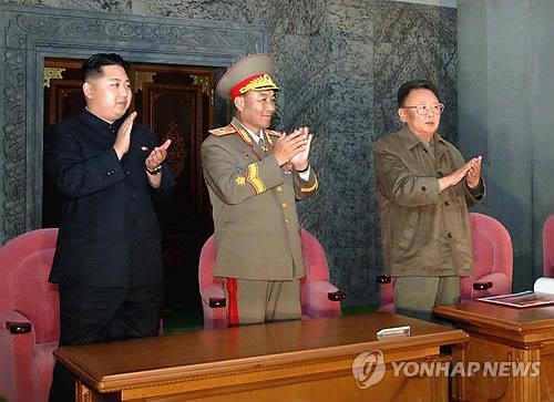 In this 2010 file photo released by the Korean Central News Agency, then North Korean leader Kim Jong-il (R) and his son Kim Jong-un (L) clap during a grand evening gala to mark the 65th anniversary of the ruling Workers' Party's founding at the Kim Il-sung Square in Pyongyang. (For Use Only in the Republic of Korea. No Redistribution) (Yonhap)
