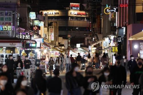 A street in Hongdae, one of the busiest entertainment districts in Seoul, is crowded with people on April 13, 2022, as South Korea moves to ease antivirus social distancing rules. (Yonhap)