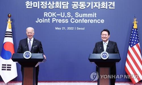 President Yoon Suk-yeol (R) and U.S. President Joe Biden smile during a joint news conference after their talks at the presidential office in Seoul on May 21, 2022. (Yonhap)