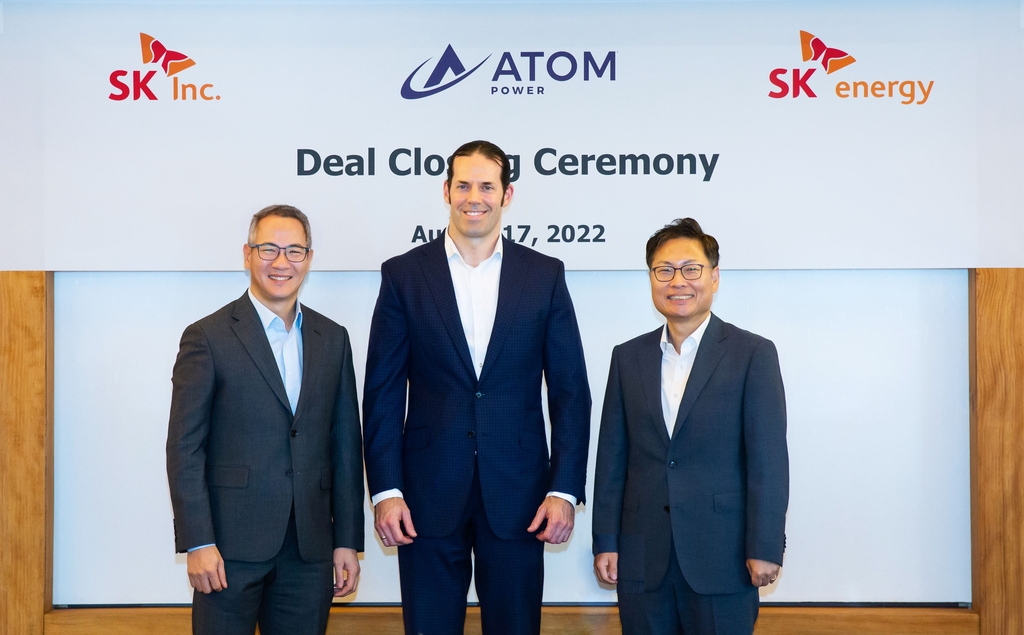 From left to right: Kim Moo-hwan, vice president and head of SK's Green Investment Center, and Ryan Kennedy, Atom Power CEO, pose for a photo with Kang Dong-soo, head of SK Energy's S&P promotion team, at the deal-closing ceremony for SK's takeover of Atom Power Inc., a U.S. energy solutions company, in this photo provided by SK Inc. on Aug. 18, 2022. (PHOTO NOT FOR SALE) (Yonhap)