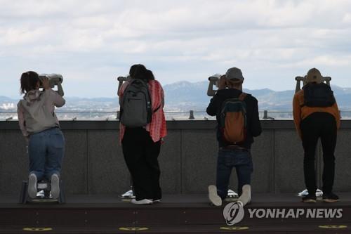 Visitors to Dora Observatory in Paju, located between Seoul and the inter-Korean border, look through binoculars into North Korean territory in this file photo taken on Oct. 5, 2022. (Yonhap)
