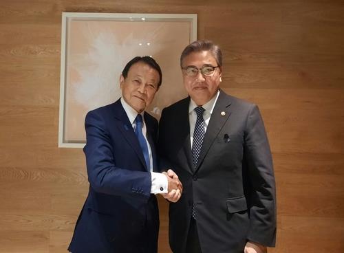 South Korean Foreign Minister Park Jin (R) shakes hands with former Japanese Prime Minister Taro Aso at a breakfast meeting in a Seoul hotel on Nov. 3, 2022, in this photo provided by Park's office. (PHOTO NOT FOR SALE) (Yonhap)