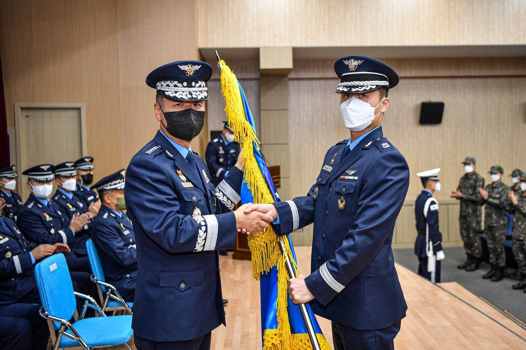 Air Force Chief of Staff Gen. Jung Sang-hwa (L) hands the flag of the newly launched Space Operations Squadron to Maj. Kim Jong-ha, the head of the unit, during a launch ceremony at Osan Air Base in Pyeongtaek, 65 kilometers south of Seoul, on Dec. 1, 2022 in this photo released by the Air Force. (PHOTO NOT FOR SALE) (Yonhap)