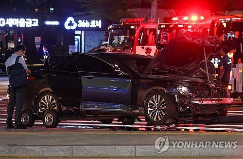 Police officers inspect a sedan that crashed into pedestrians and other vehicles in downtown Seoul on July 1, 2024, killing nine people. (Yonhap)