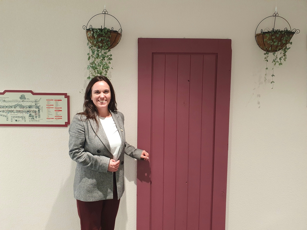 Geneviève Rolland devant la réplique de la «porte rouge» apparaissant dans la série TV coréenne «Goblin», au Bureau du Québec à Séoul, le mercredi 8 février 2023. La porte originale se trouve près du théâtre Petit Champlain à la ville de Québec, au Canada.