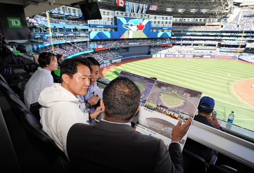 Cette photo fournie par la ville de Séoul montre le maire Oh Se-hoon (2e à partir de la droite) assis dans la loge du Rogers Center à Toronto, au Canada, le 16 septembre 2023. (Archivage et revente interdits)