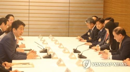安倍晋三首相（左端）と会談する姜昌一・韓日議員連盟会長（右端）＝２１日、東京（聯合ニュース）