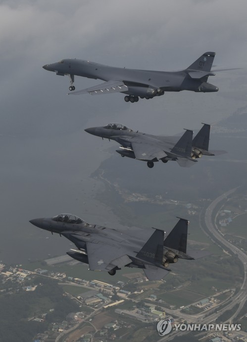 韓国空軍のＦ１５（上）と共に在韓米軍烏山空軍基地の上空を飛ぶ２機の米戦略爆撃機Ｂ１Ｂ（韓国空軍提供）＝３０日、ソウル（聯合ニュース）