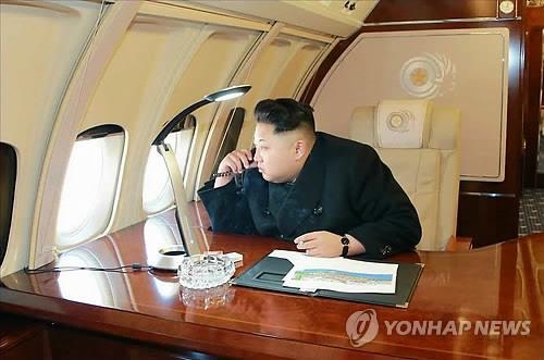 専用機内から外を眺める金正恩氏。１５年２月に北朝鮮メディアが写真を掲載した（資料写真）＝（聯合ニュース）