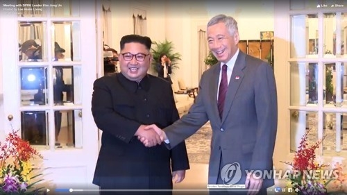 会談前に握手する金委員長（左）とリー首相（ストレーツ・タイムズの映像より）＝１０日、シンガポール（聯合ニュース） 