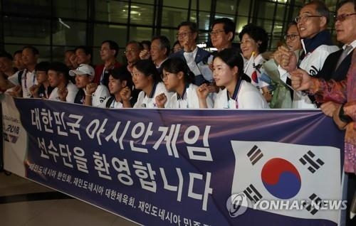 空港到着後、記念撮影する韓国選手団＝１５日、ジャカルタ（聯合ニュース）