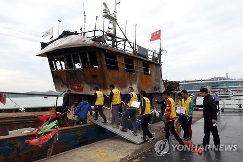 中어선 화재 현장재연 나선 선원들(목포=연합뉴스) 정회성 기자 = 11일 오후 전남 목포시 삼학도 해경전용부두에서 중국 어선 소감어04012호 선원들이 조타실 화재 사건 현장재연을 위해 계류 중인 선박에 오르고 있다.