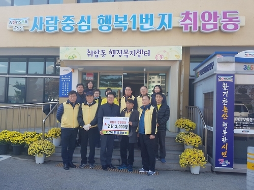 논산사랑요양병원 직원들이 박용규 취암동장(사진 앞줄 가운데)에게 연탄을 기증하고 있다.