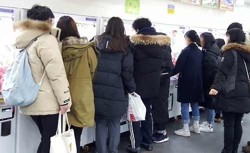 인형 뽑기 기계 앞에 몰린 사람들