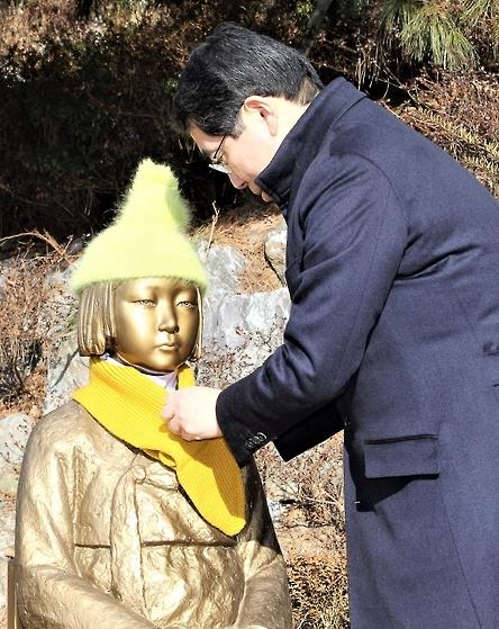 양기대 광명시장이 광명동굴 앞 '광명 평화의 소녀상'에 노란색 목도리를 둘러 여며주고 있다.(광명시 제공=연합뉴스)