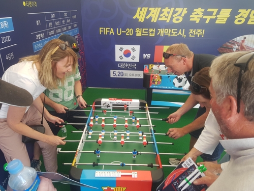 전주영화제 행사장내에 마련된 U-20 체험장에서 외국인들이 게임을 즐기고 있다.