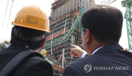 부러진 타워 크레인 붐대 살펴보는 현장 관계자