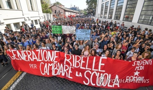 이탈리아 학생들이 '학교를 바꾸기 위한 반항의 세대'라는 문구가 적힌 현수막을 펼쳐든 채 13일 로마 도심에서 행진을 벌이고 있다. [EPA=연합뉴스] 