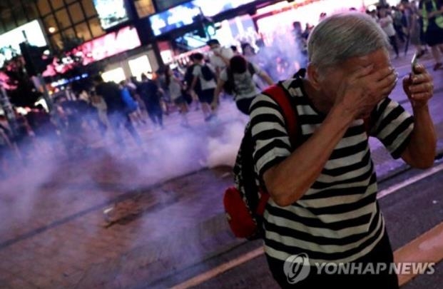 지난 8일 경찰이 쏜 최루탄을 피해 달아나는 홍콩 시민들