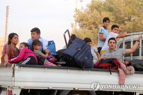 지난 10일(현지시간) 터키의 침공에 시리아 북부 쿠르드인 가족이 피란을 떠나고 있다.[EPA=연합뉴스]