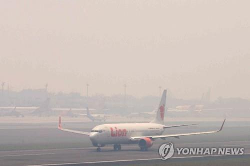 팔렘방 공항 활주로에 가득 찬 산불 연기
