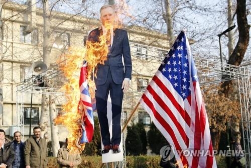 14일 테헤란 대학에서 열린 반서방 집회에서 영국 대사의 사진이 불타고 있다.