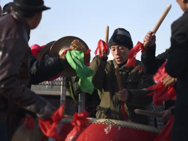 Bai Haiquan is playing the drum for the village yangko performance group on Jan. 17.