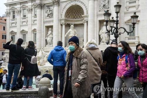 마스크를 쓴 채 로마 트레비 분수 앞을 지나는 관광객들
